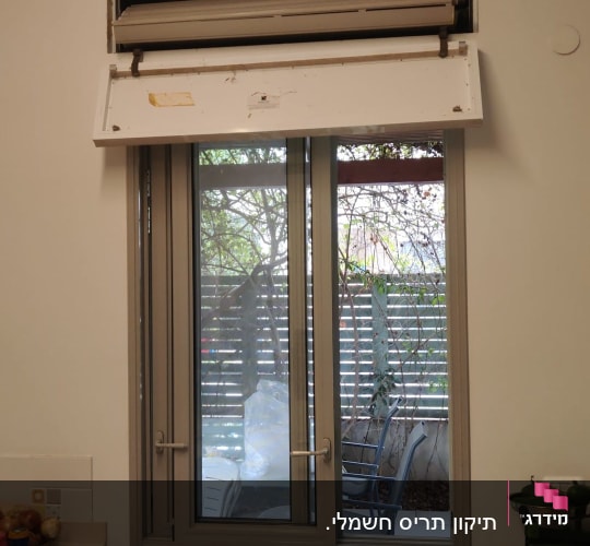 חלון עם תריס פתוח במטבח, כיסאות פלסטיק בחוץ